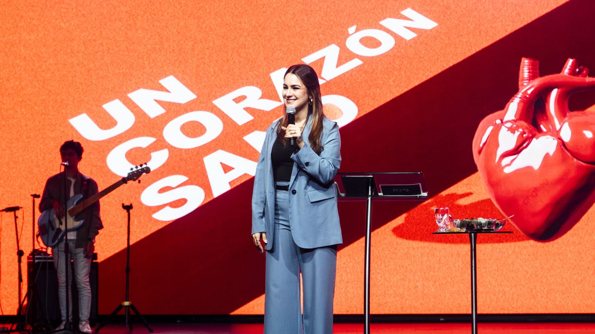 Michelle Ruiz predicando en el escenario de «Un corazón sano», con la banda al fondo.