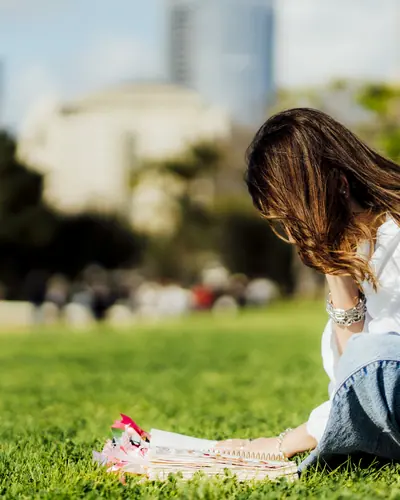 Michelle Ruiz sobre el césped, inclinada sobre su Biblia abierta.